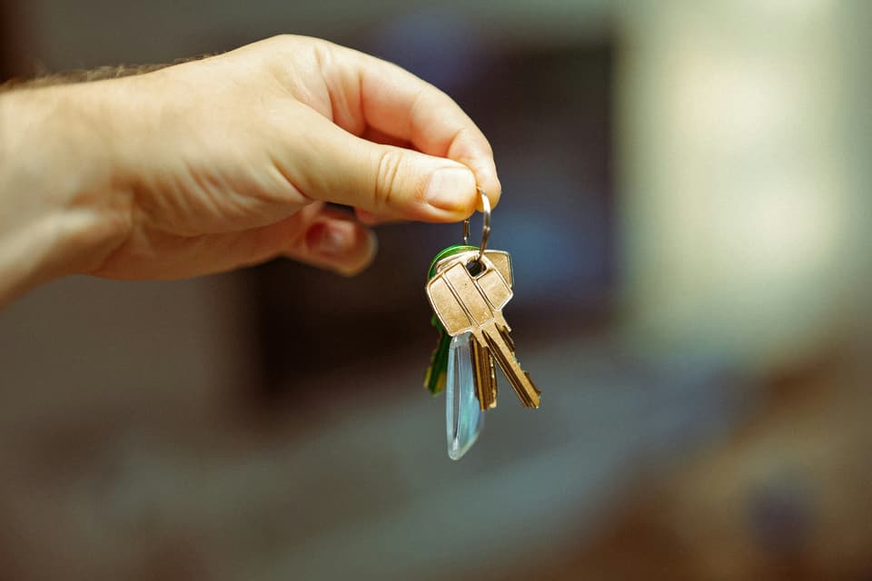A hand holding a ring of house keys